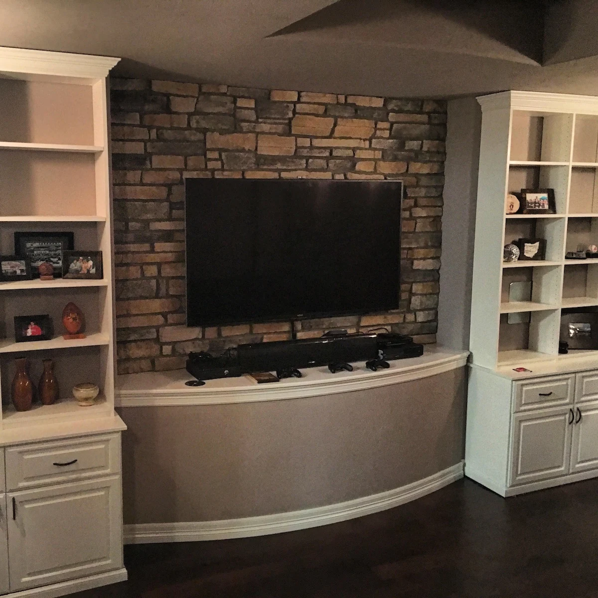 Stone feature wall between white built-in shelves